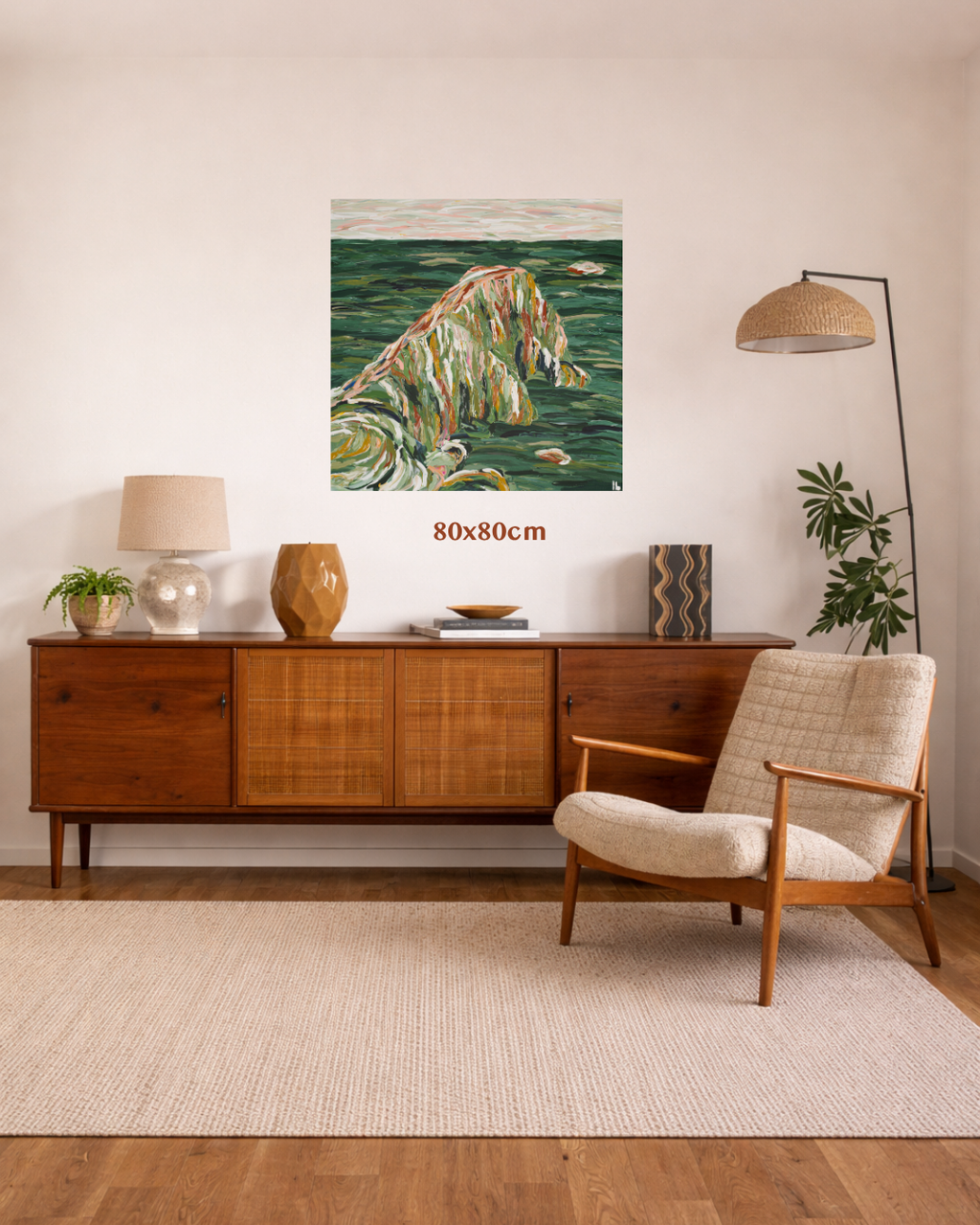 A mid-century modern living room featuring a square canvas art print of a textured green and beige wave painting, displayed on a cream wall above a wooden credenza. The print includes a red text overlay reading '80x80cm'. Art by Australian Tasmanian abstract artist Lucy Bauld. 