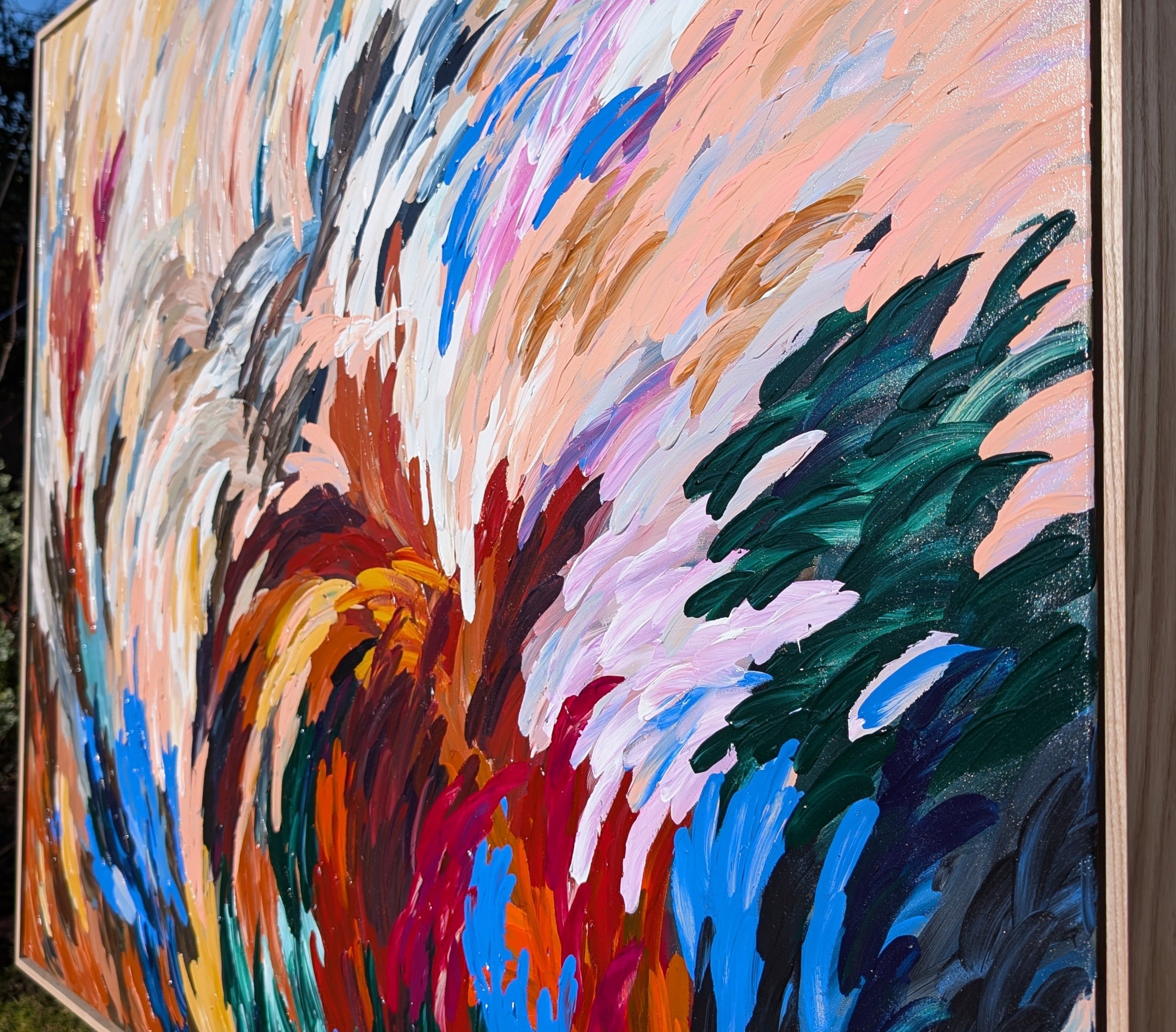 Bold statement texture abstract painting with details and with energetic but calm colors of red, blue, neutral earthy tones in an oak frame